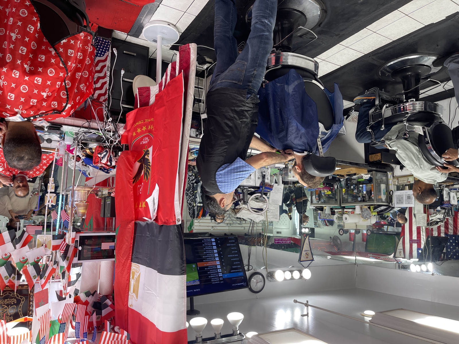 Two barbers working across the shop floor at once