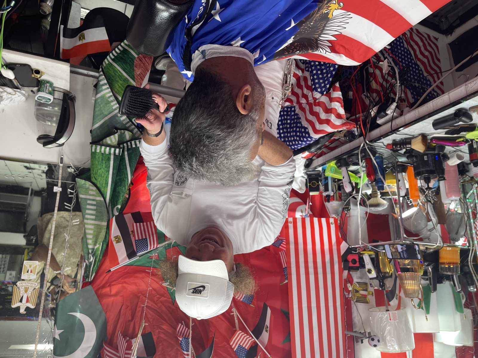 A barber shaping a fade with clippers