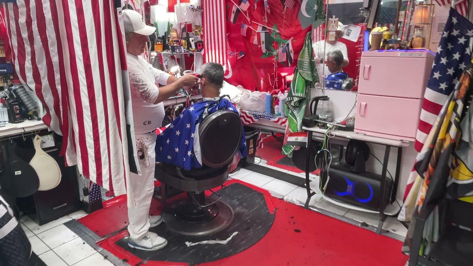 A wide view of the Makkah Barber Shop floor, with a barber working at the chair